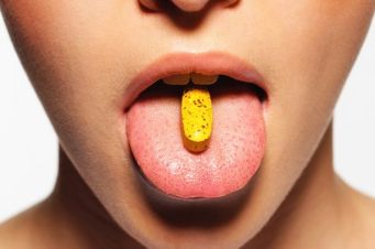 young-woman-with-pill-on-tongue-close-up